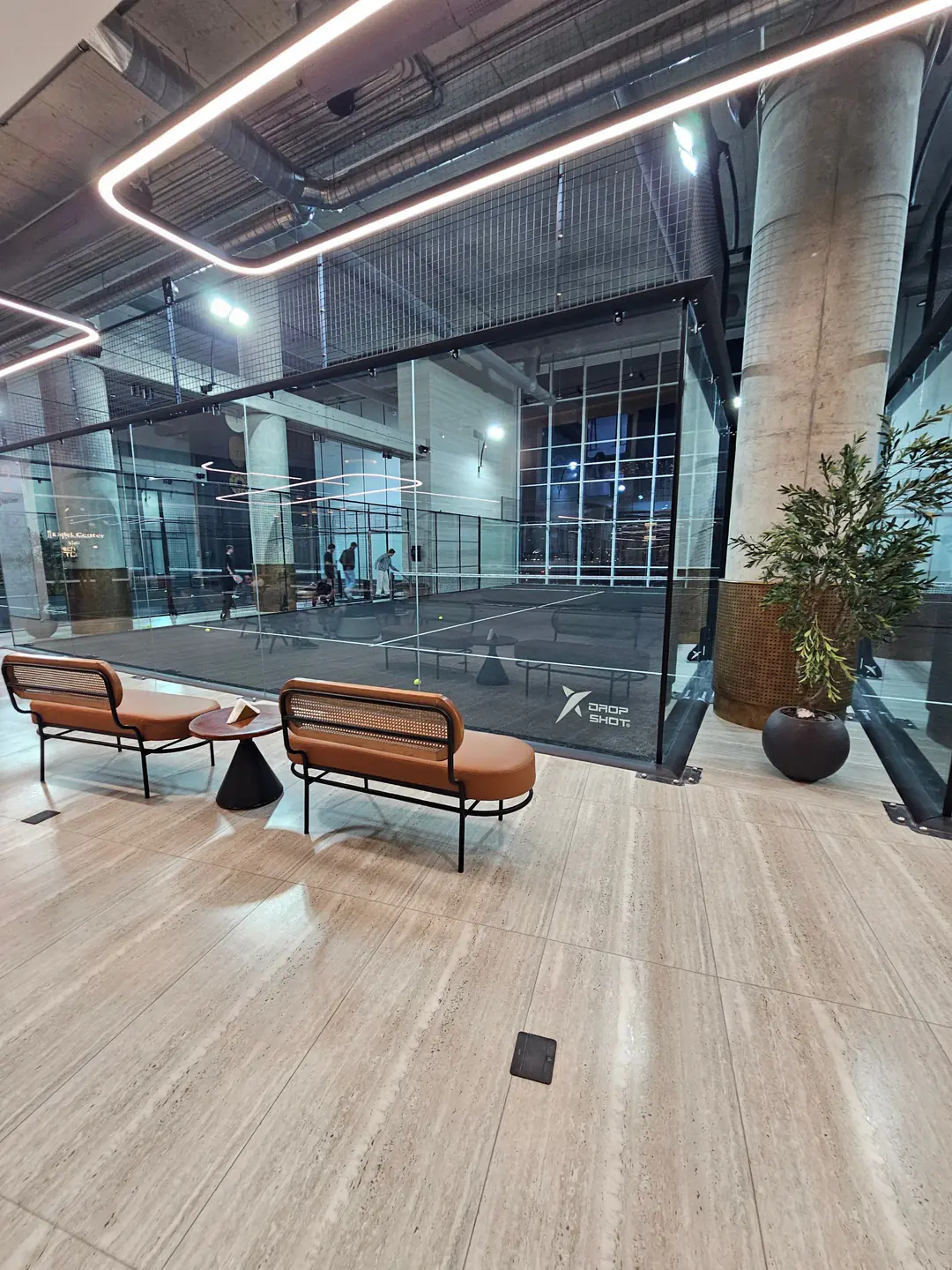 The Padel Center lounge beside its indoor glass courts